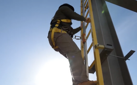 Worker climbing up tower while wearing the French Creek 800 Series Tower Climbing Harness.
