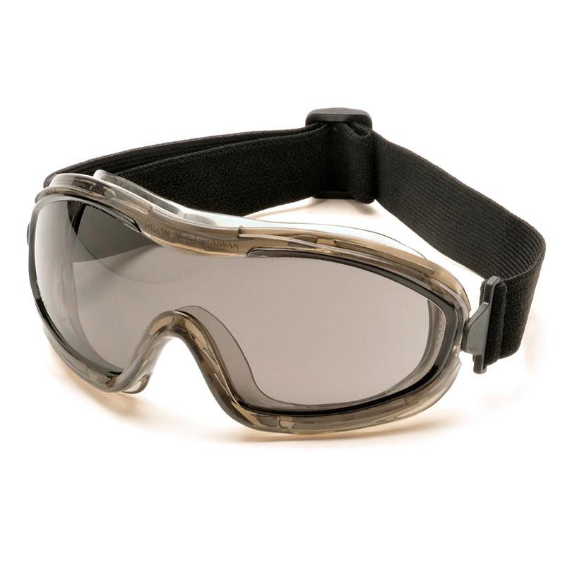 The Pyramex Low-Profile Chemical Splash Goggle by Pyramex Safety includes a transparent lens, a black adjustable strap, and a gray frame. With a modern sport design that ensures durability, these goggles meet ANSI Z87.1-2003 compliance standards and are perfect for lab work or construction safety.