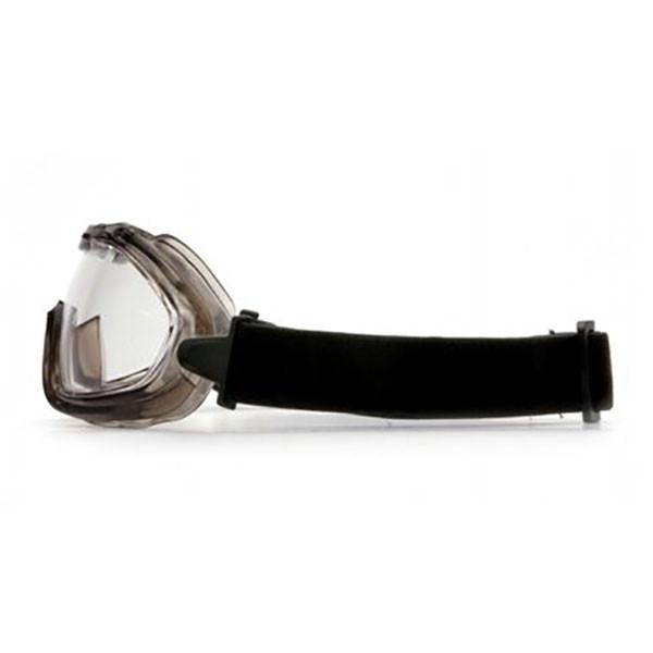 Featuring a side view of the Pyramex Low-Profile Chemical Splash Goggle from Pyramex Safety, this protective eyewear includes a black elastic strap for secure fastening. It has a clear lens with a slightly tinted, durable frame that showcases a modern sport design. Ideal for both safety and sports use, these goggles are compliant with ANSI Z87.1-2003 standards.